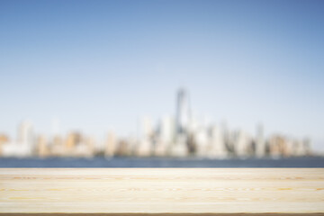 Naklejka premium Blank tabletop made of wooden planks with beautiful blurry cityscape in the afternoon on background, mockup