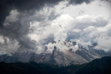 Fototapeta premium Marmolada Peak - 3343meters, the highest mountain in the Dolomites, Italy, with dramatic sky and fog