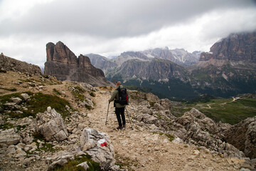 Fototapeta na wymiar Man traveler traveling alone in breathtaking landscape of Dolomites Mounatains. Travel lifestyle wanderlust adventure concept.
