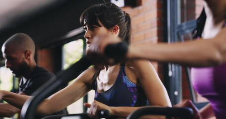 Exercise woman, gym bike and class cycling for cardio performance, wellness or club resilience fitness, aerobics or activity. Female athlete, stationary air bicycle machine and group training workout