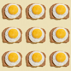 Seamless pattern with dark bread and sunny side up egg on beige background.