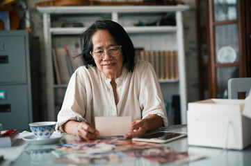 old woman looking at old family photographs