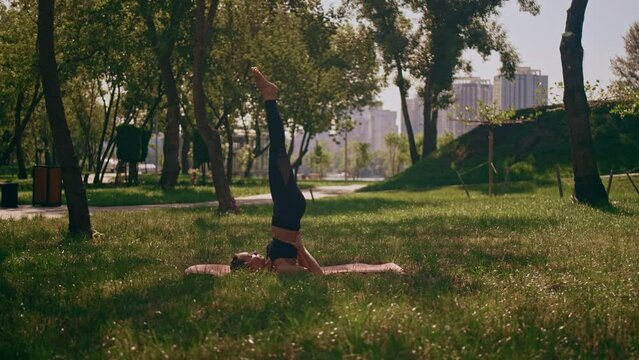 woman dressed activewear lying on yoga mat doing workout outdoors in summer city park active fitness lifestyle