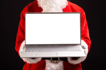 Santa claus holding laptop with copy space on black background