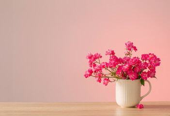 pink roses in ceramic vase on pink background