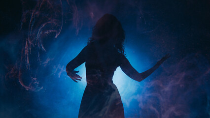 Mysterious dance. Spiritual aura. Energetic woman silhouette moving in glowing swirls mist shadow...