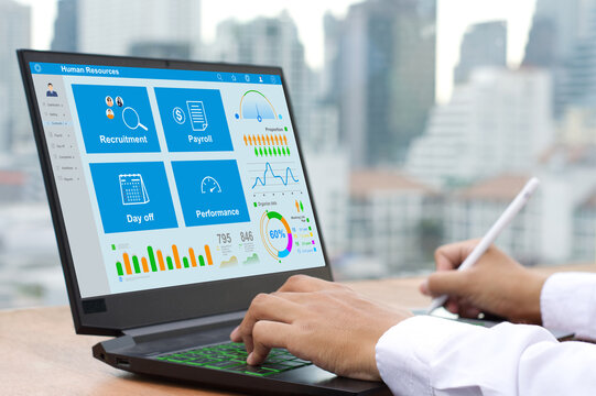  An HR officer uses HR software on a laptop to manage and summarize payroll, holiday leave, and recruitment.