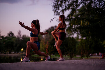 Fototapeta na wymiar Fit Girls Training Outdoors in a Green Environment at Night