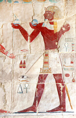 Ancient Colorful Mural Wall Painting inside Hatshepsut Temple in Valley of the Kings, Luxor, Egypt. Figure of pharaoh making ritual offerings, wall of the Hatshepsut temple in Western Thebes © frenta