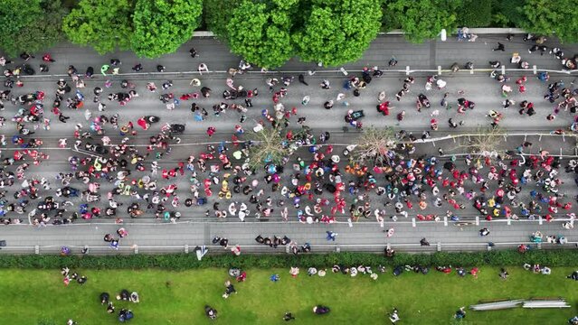 Start line of marathon with people gathering on street during running event, top down