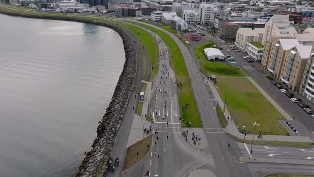 People running the Reykjavik marathon in Iceland along sea shore, aerial