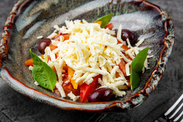salad with tomatoes, basil, sweet peppers and cheese, side view