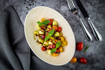  salad of yellow and red cherry tomatoes of different varieties with herbs top view