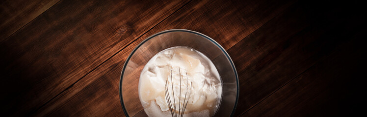 Bakery whisk in cream ingredients for cake. Bakery concept background.
