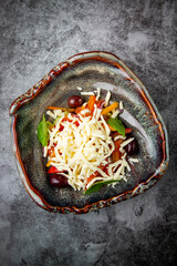 salad with tomatoes, basil, sweet peppers and cheese, top view