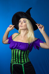 Blonde woman in black witch hat wearing costume for Halloween