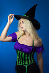 Blonde woman in black witch hat wearing costume for Halloween