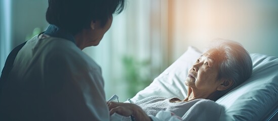Female senior patient with caregiver in hospice care receives checkup from doctor with stethoscope in hospital With copyspace for text