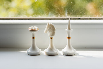 Three white chess figures knight (horse), bishop and rook. Chess game