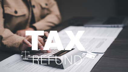 Man using a laptop with TAX REFUND and refund tax of duty taxation business, graphs and chart being...
