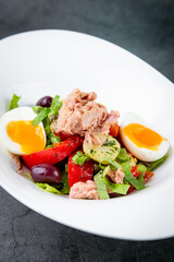 salad with soft-boiled egg, tuna, green onions, boiled potatoes, side view