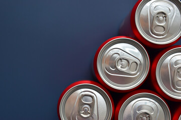 close up top of aluminium red cans soft drink put on blue texture background - obrazy, fototapety, plakaty