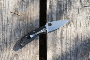 A folding pocket knife in nature with you in the forest. - obrazy, fototapety, plakaty