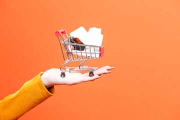 Female Woman Hand Holding Mockup Small Tiny Shopping Cart Trolley With Bunch of Medicines Against...