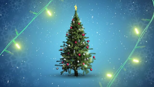 Yellow string lights flashing over decorated christmas tree and falling snow on blue background