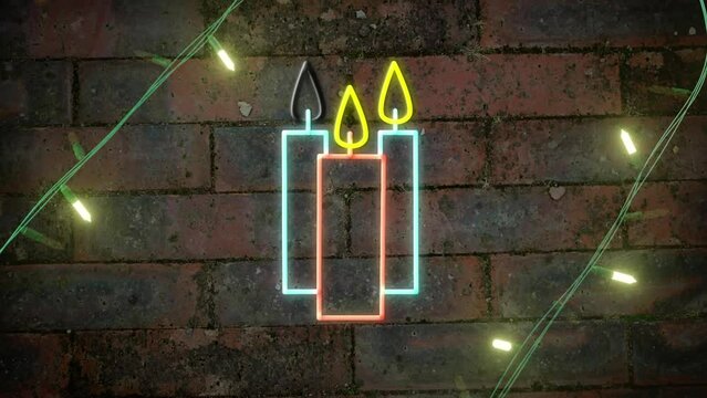 Yellow christmas string lights flashing over neon candles on brick wall