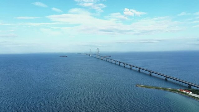 Great belt bridge fixed link crossing strait between islands of Zealand and Funen in Denmark - Stunning aerial with blue sky background