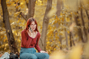 Red-haired girl talks irritably on the phone. Negative emotions, anger, bad conversation.