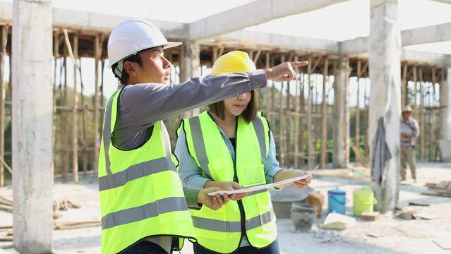 Female and male engineers survey inspection schedules for new construction projects at construction sites.