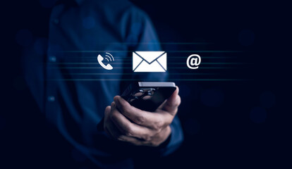 Communication and Contact us or Customer support hotline people connect. Hand using a laptop and touching on virtual screen contact icons, email and address, live chat with internet wifi.