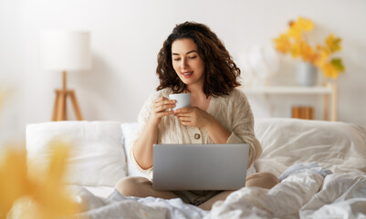 Obraz na płótnie Canvas woman wearing warm clothes is using laptop