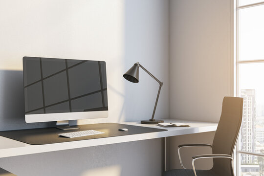 Close up of modern workplace with reflections on computer monitor, lamp and window with city view and daylight. 3D Rendering.