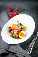 salad with soft-boiled egg, tuna, green onions, boiled potatoes, side view