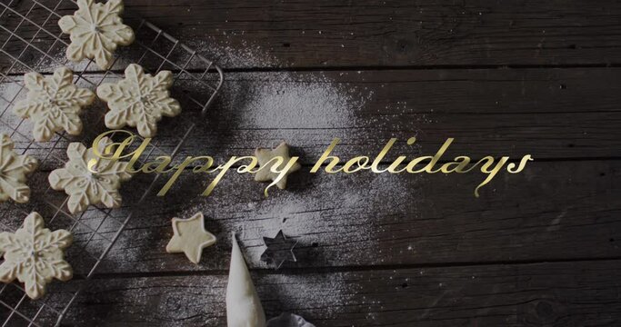 Happy holidays text win gold over snowflake christmas cookies on dark wood