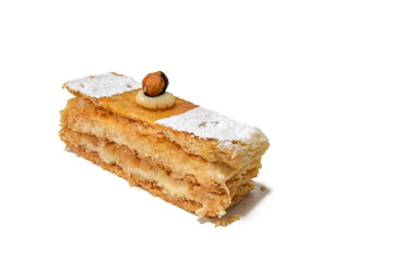 A sweet puff pastry filled with cream and a hazelnut on top, isolated on a white background.