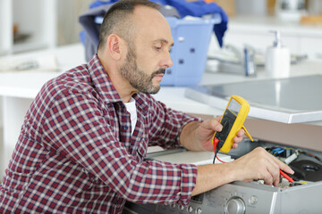 electrician measuring voltage in distribution board closeup