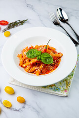 carbonara pasta with cheese and herbs on top on a white plate side view