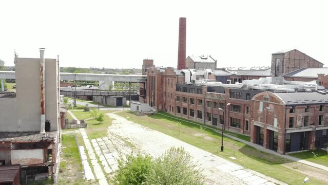 Aerial view of the Arche Hotel Żnin inside old sugar factory in Poland. The tall chimney of the factory is a prominent landmark, rising above the surrounding landscape