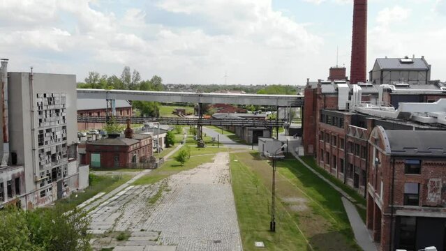 Aerial view of a historic sugar factory in Żnin, Poland. The factory is a large, imposing structure with a red brick exterior.