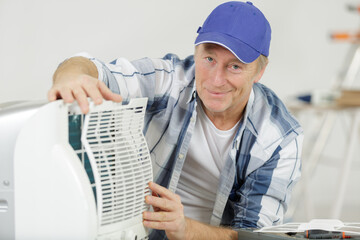 man assembling air conditioning unit