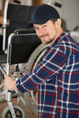 man is repairing a wheelchair at workshop