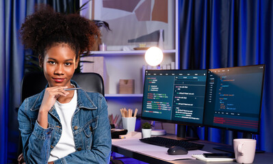 Young African wearing jeans shirt, IT developer presenting program on computer screens displaying...