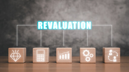 Revaluation concept, Wooden block on desk with revaluation icon on virtual screen. - obrazy, fototapety, plakaty