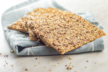 Knackebrot with sesame seeds. Wholegrain crispbread on napkin on kitchen table.
