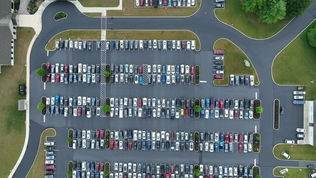 Parking lot filled with cars. No spots in entire lot. Filled to capacity. Aerial top down shot.
