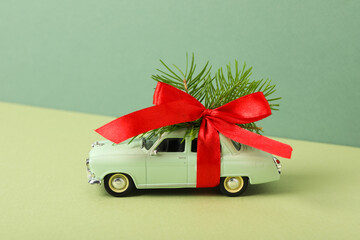 A green car with a Christmas tree and a red bow.